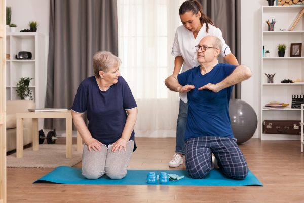 Assistance doing physiotherapy at home with old people. Home assistance, physiotherapy, healthy lifestyle for senior old person, training and recovery with professional doctor.